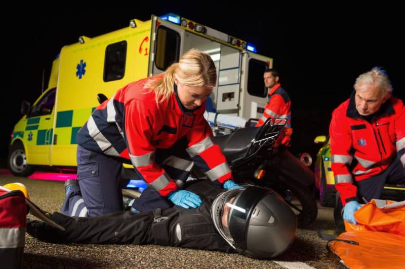 Ambulance team treating someone on the road
